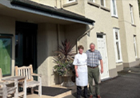2 people standing outside of the hotel